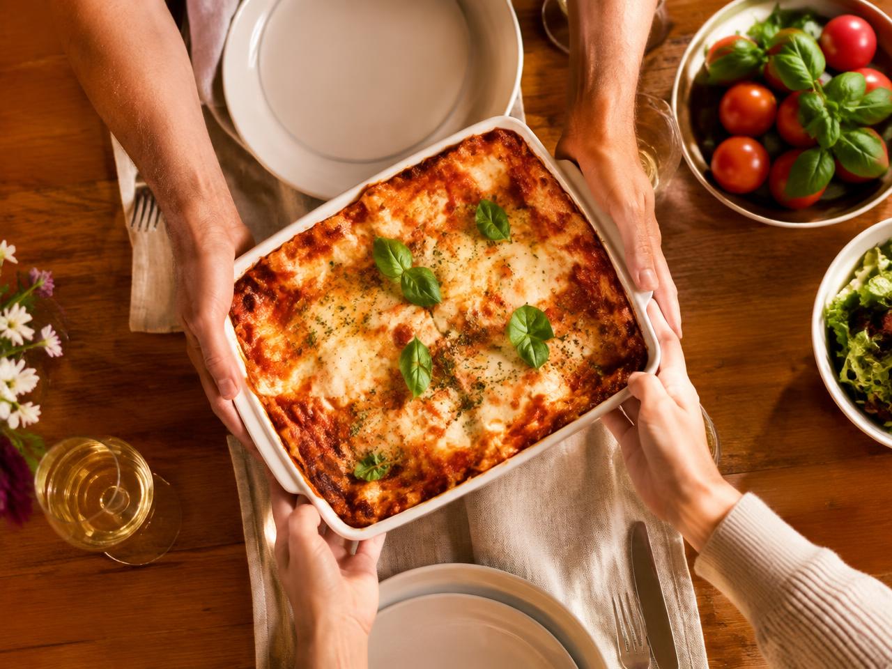 Neighbors passing a homemade lasagna across a table
